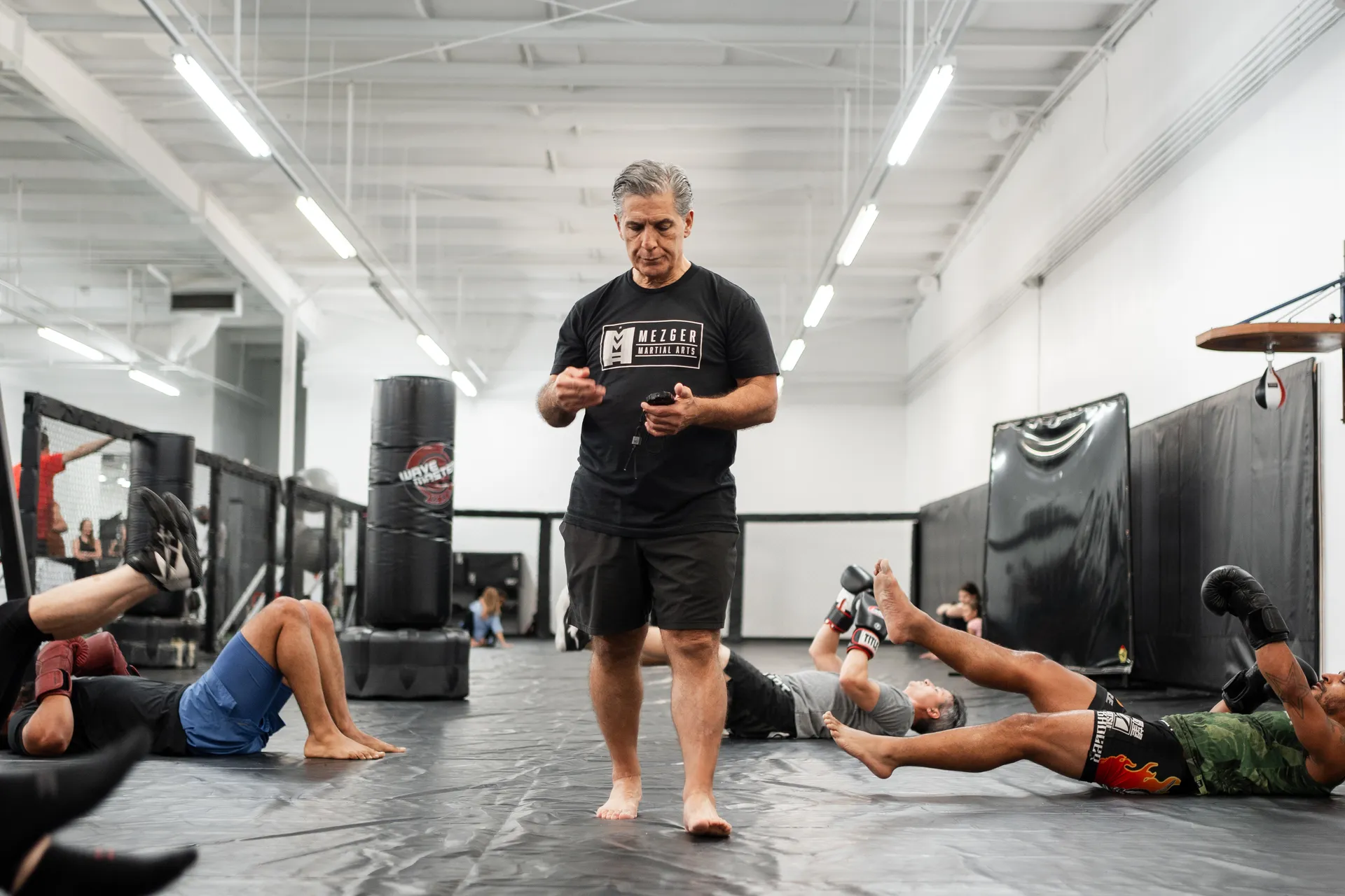 Guy Mezger coaching a grappling class on the mats